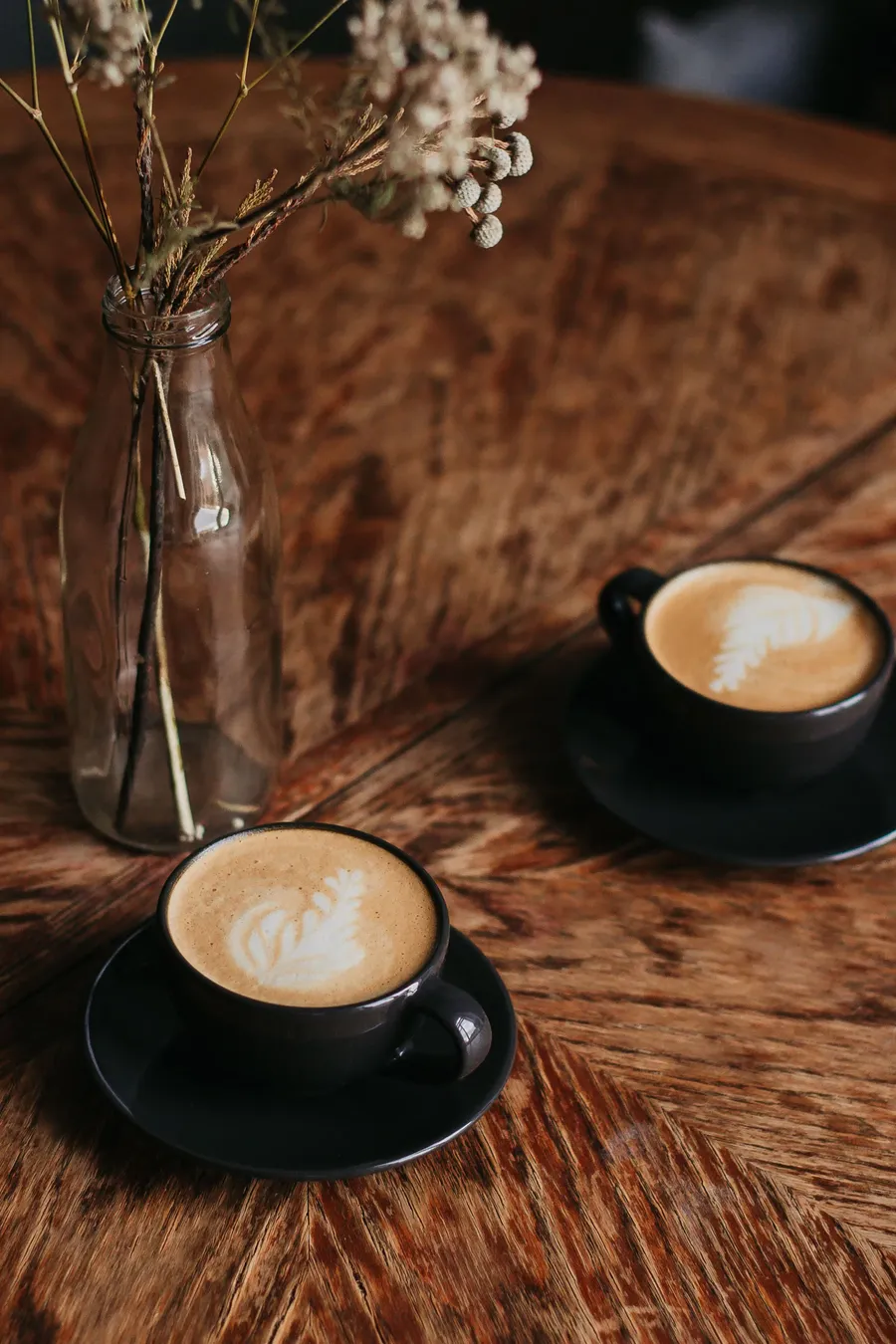 Dos tazas de café sobre una mesa de madera