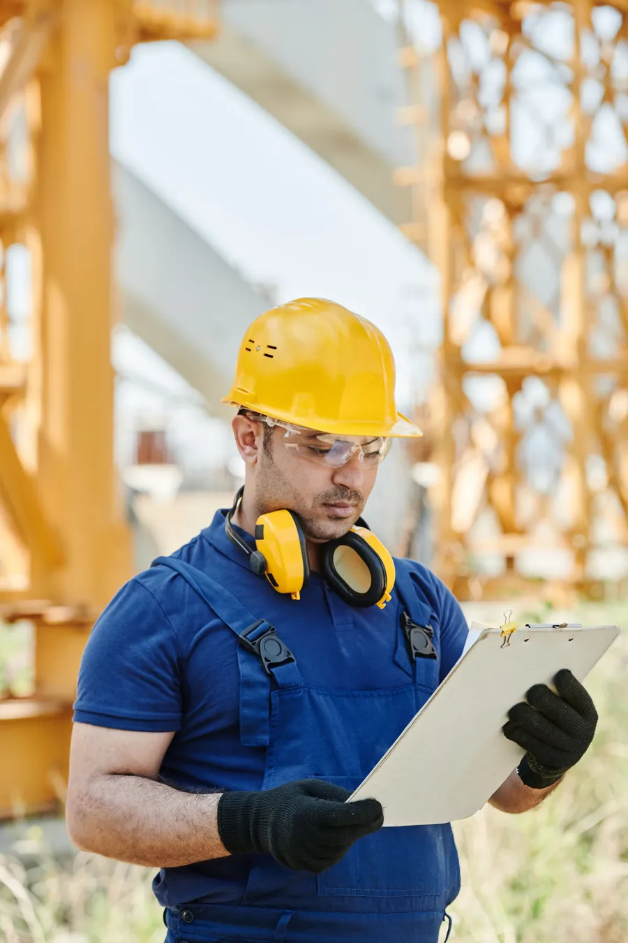 Contratista con casco frente a una obra en construcción