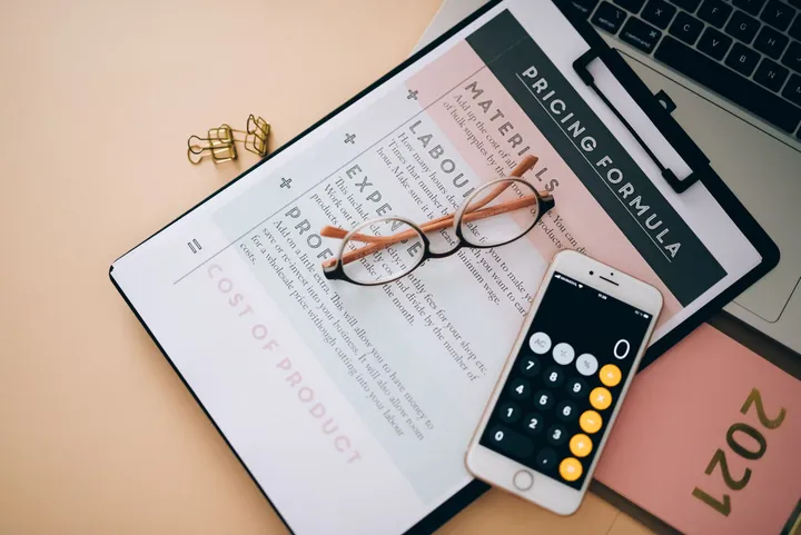 Escritorio con una tableta, gafas y una calculadora