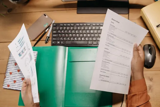 Manos revisando un balance financiero sobre un escritorio