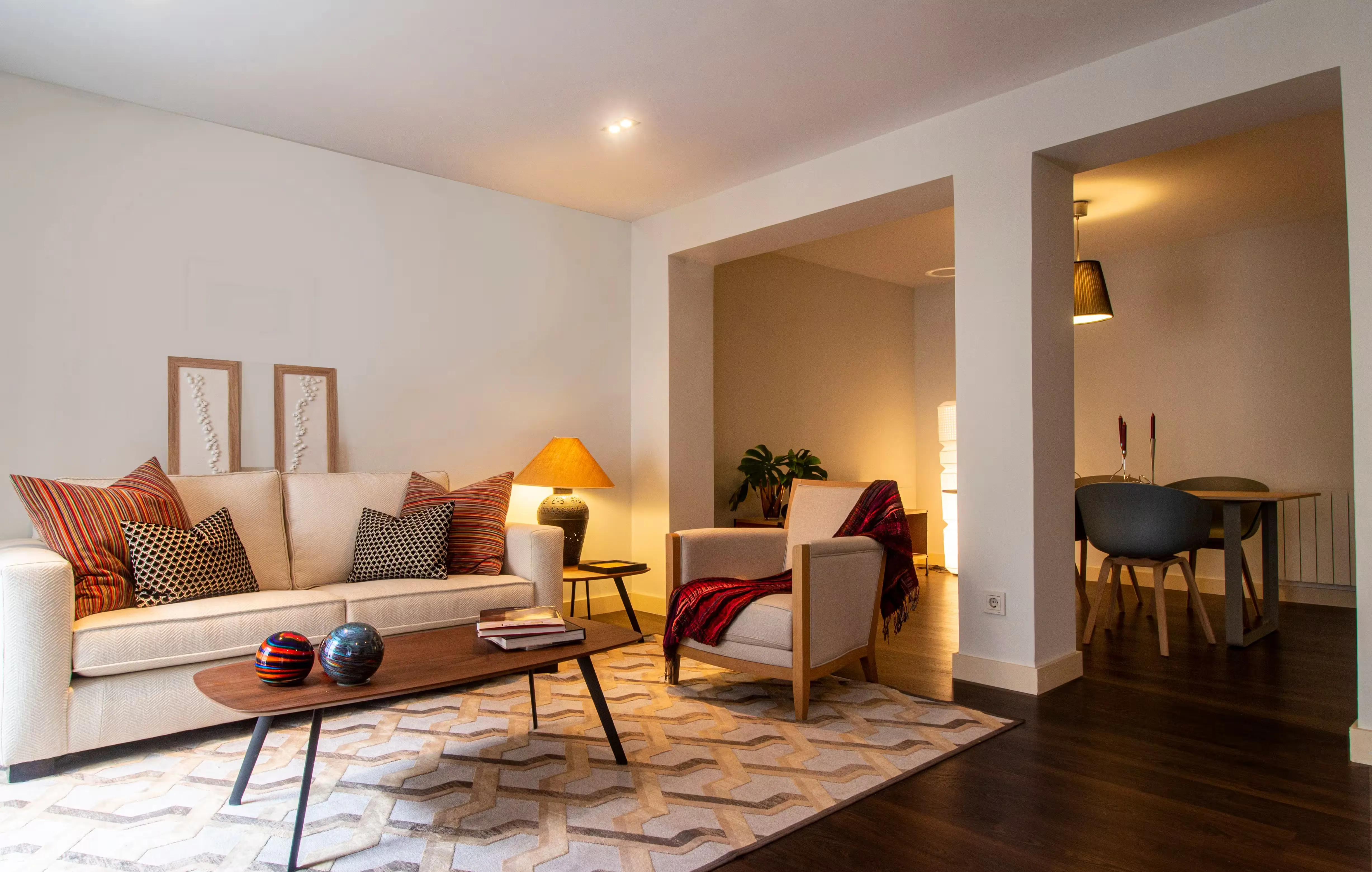 Sala de un apartamento con sofá, mesa de centro y comedor al fondo