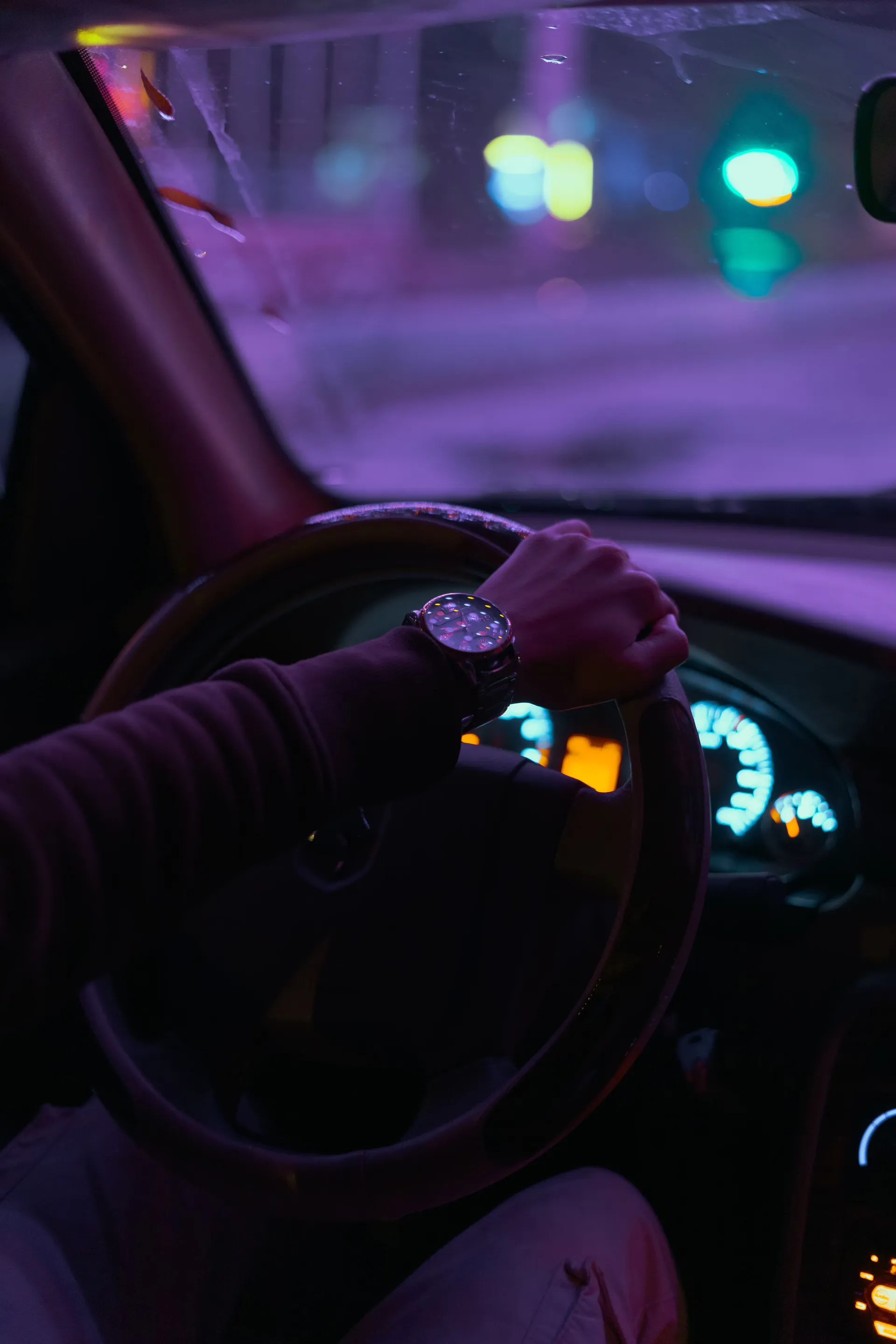 Manos sobre el volante de un carro conduciendo de noche