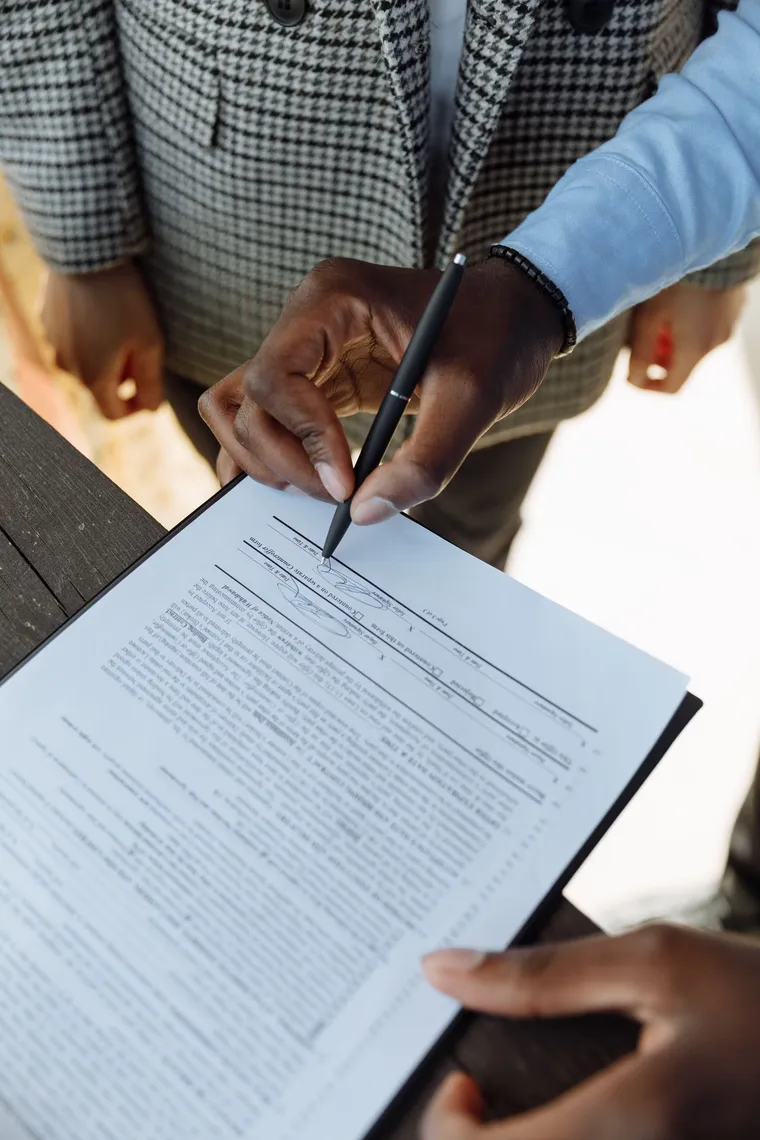 Persona firmando un formulario sobre un escritorio