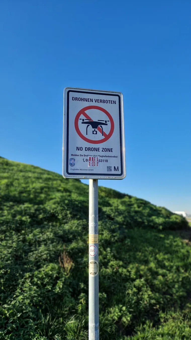Señal de zona prohibida para drones sobre una colina verde