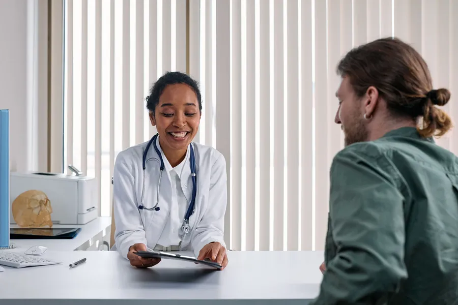 Médica conversando con un paciente en su consultorio