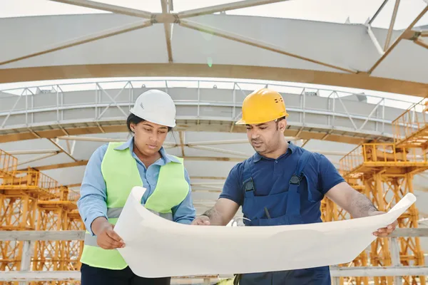 Trabajadores con casco y elementos de protección en obra